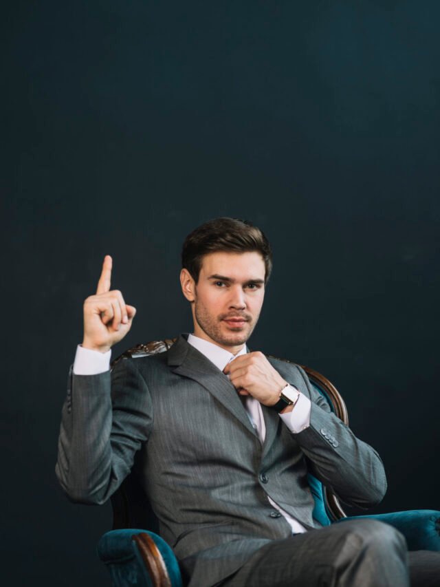 young-businessman-sitting-armchair-showing-hand-with-one-finger-up