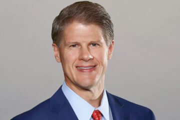 Clark Hunt, chairman of the Kansas City Chiefs, standing at Arrowhead Stadium, symbolizing leadership and success in the NFL.